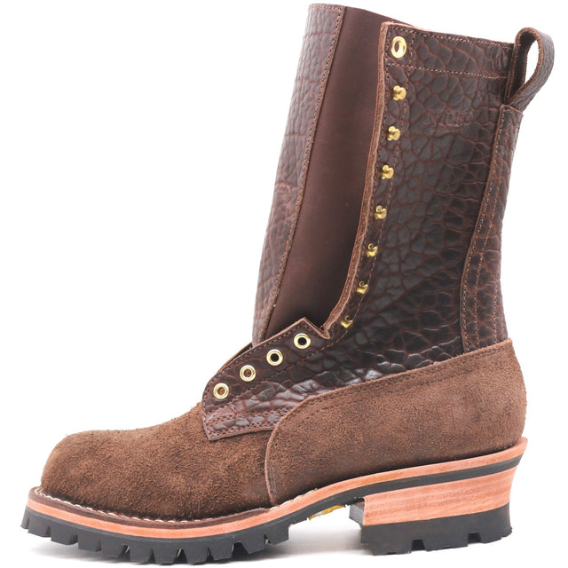 Tall brown textured shrunken bison leather boot with a padded gusset, brass hardware, rear pull loop, and lug outsole in front of a white background.