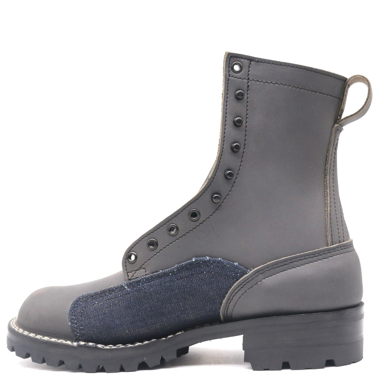 A dark gray leather lace-up ankle boot with a dark blue denim patch on the side and a thick black lug sole, shown from a side profile on a white background.