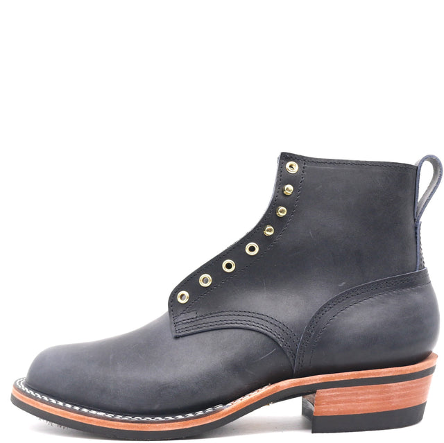 A single dark blue leather ankle boot with gold-tone metal eyelets, a pull tab, and a stacked black and brown heel, shown from a side profile on a white background.