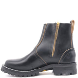 A black leather Chelsea-style ankle boot with a gold zipper, contrast stitching, and a rugged lug sole, shown from a side profile on a white background.