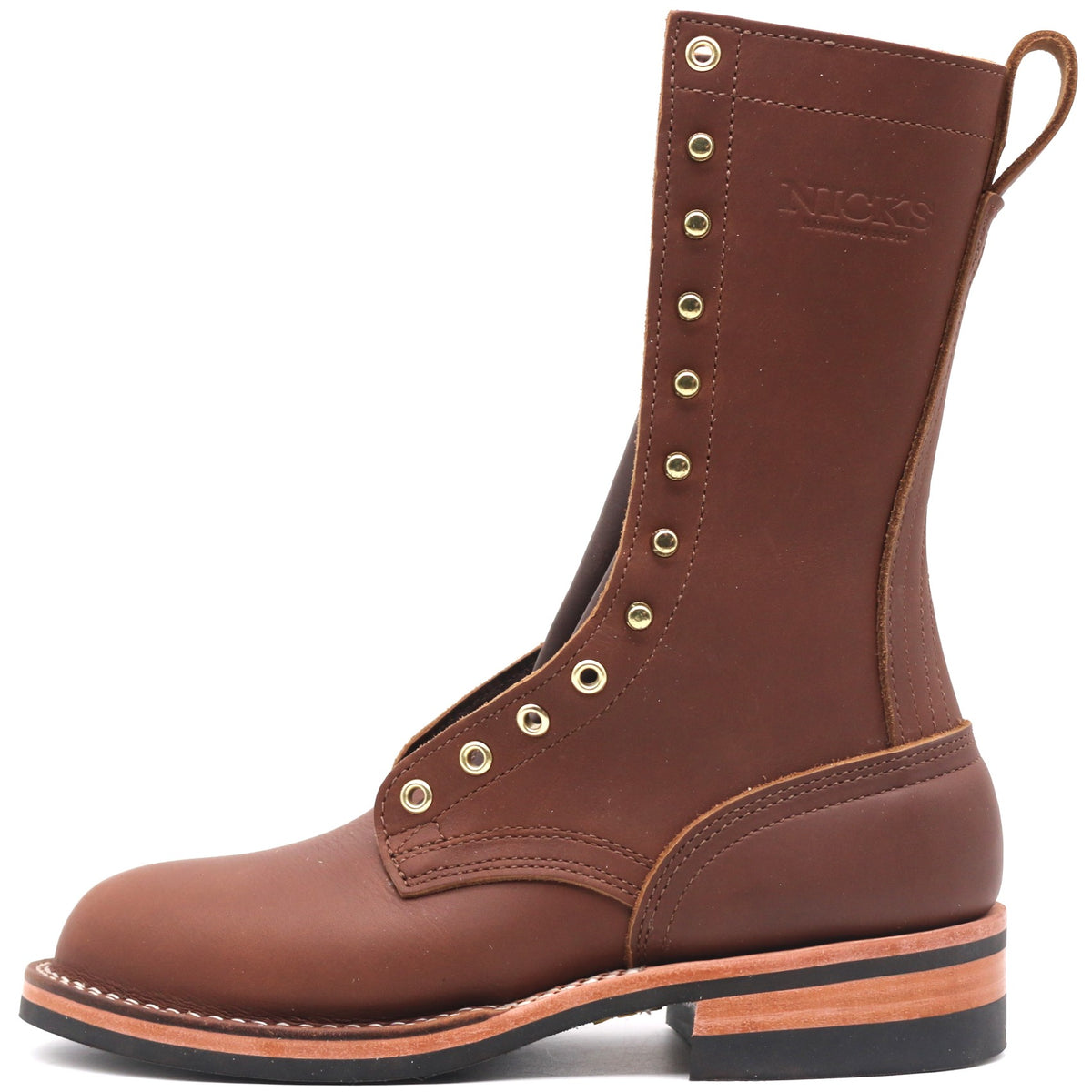 A brown leather lace-up work boot with brass eyelets, a pull loop, and a stacked sole, shown from a side profile on a white background. The brand name 'NICKS' is embossed on the side shaft.
