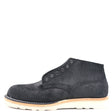 A single black suede chukka boot with metal eyelets and a thick off-white sole, shown from a side profile on a solid white background.