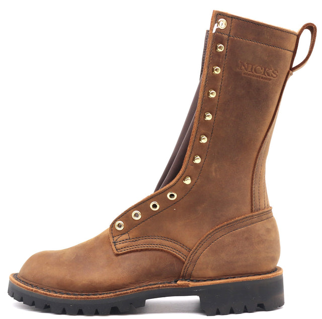 A brown leather mid-calf work boot with gold-tone metal eyelets and studs, featuring a pull tab and the brand name 'NICKS' embossed on the side, set against a plain white background.