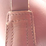 Close-up of a brown leather strap with visible stitching and a slightly worn texture against a matching brown leather background.