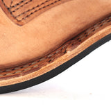 Close-up of a light brown leather shoe corner showing the stitched vamp, layered leather edge, and black outsole against a white background.