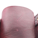 Close-up of a dark burgundy leather strap or belt section showing the textured leather surface and stitching against a white background.