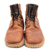 A pair of brown leather lace-up ankle boots with dark brown leather cuffs, brass eyelets, and a thick lug sole, shown against a plain white background.