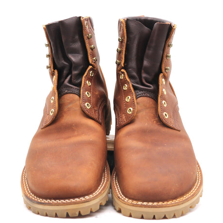 A pair of brown leather lace-up ankle boots with dark brown leather cuffs, brass eyelets, and a thick lug sole, shown against a plain white background.