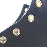 Close up of the hardware of a black leather boot. The hardware is visibly mis-spaced.