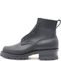 A black leather ankle boot with lace-up front, metal eyelets, a pull tab, and a chunky lug sole, shown from a side profile on a white background. The brand name 'NICKS' is embossed on the side.