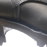 Close-up detail of a black leather boot showing the side panel, stitching, and a portion of the sole.
