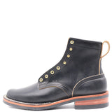 A black leather lace-up ankle boot with brass eyelets, contrast stitching, and a stacked brown and black sole, shown from a side profile on a white background.