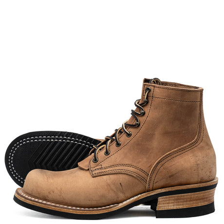 A pair of men's lace-up ankle boots in light brown leather, with one boot standing upright and the other lying on its side to show the black outsole.