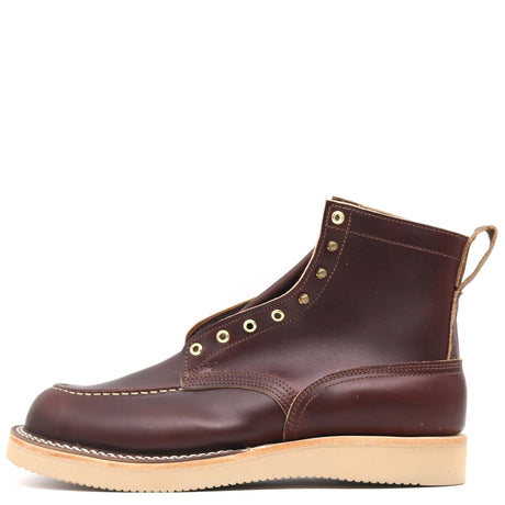 A dark brown leather ankle boot with brass eyelets, contrast stitching, and a light tan sole, shown from a side profile on a white background.
