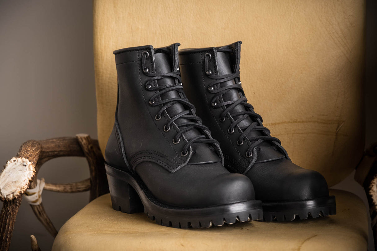Black Becca boots with lug soles on chair