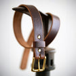 Brown belt wrapped around boot making stand