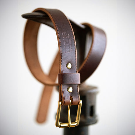 Brown belt wrapped around boot making stand