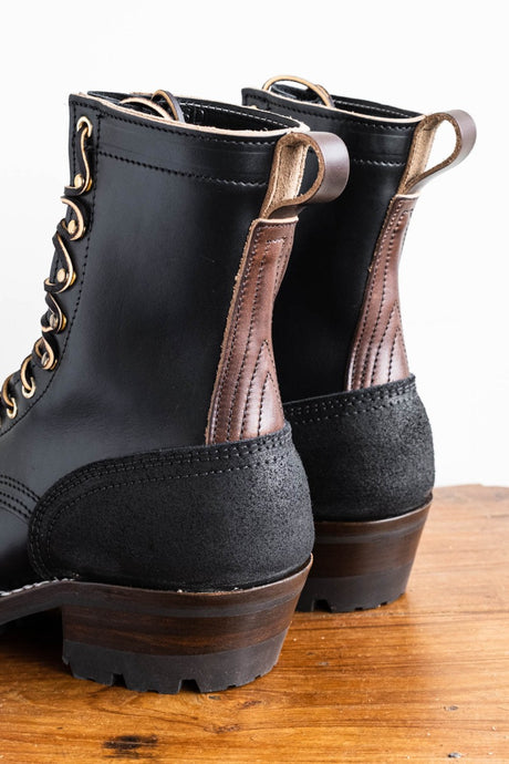 Eight inch tall black leather boot with rubber sole.  Back of boot.