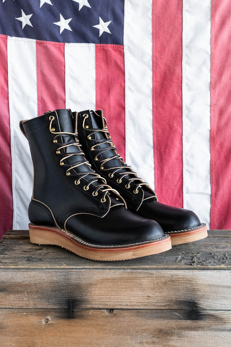 Black eight inch boot with tan backstay and vibram foam wedge sole.