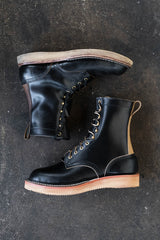 Black eight inch boot with tan backstay and vibram foam wedge sole.