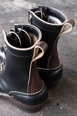 Eight inch tall black leather boot with brown backstay with a rubber sole.