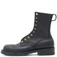 Black boot with gold buttons on a white background