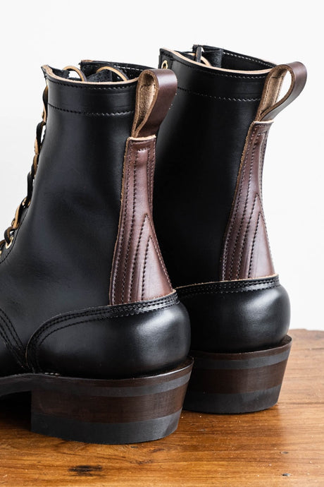Eight inch tall black leather boot with brown backstay with a rubber sole.