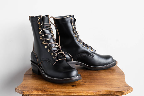 Eight inch tall black leather boot with brown backstay with a rubber sole.