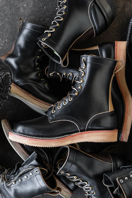 Black eight inch boot with tan backstay and vibram foam wedge sole.